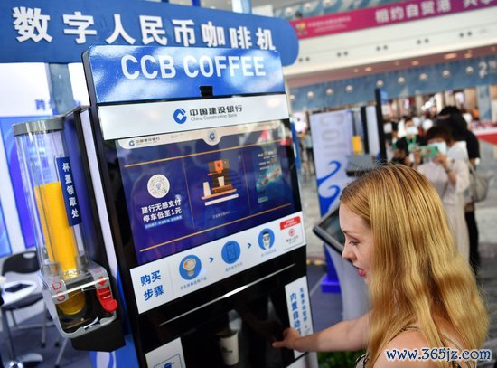 在中国海南海口举办的中国国际消费品博览会上，一名外国参观者使用数字人民币咖啡机购买咖啡　中新社∕发